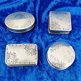 Pewter cremation urns - small different shaped urns with various decorative etchings.