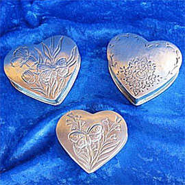 Pewter cremation urns - small heart shaped urns with decorative etchings.